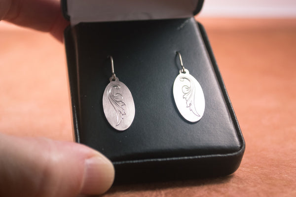 Hand-engraved titanium earrings by Podforge in a black leatherette gift box